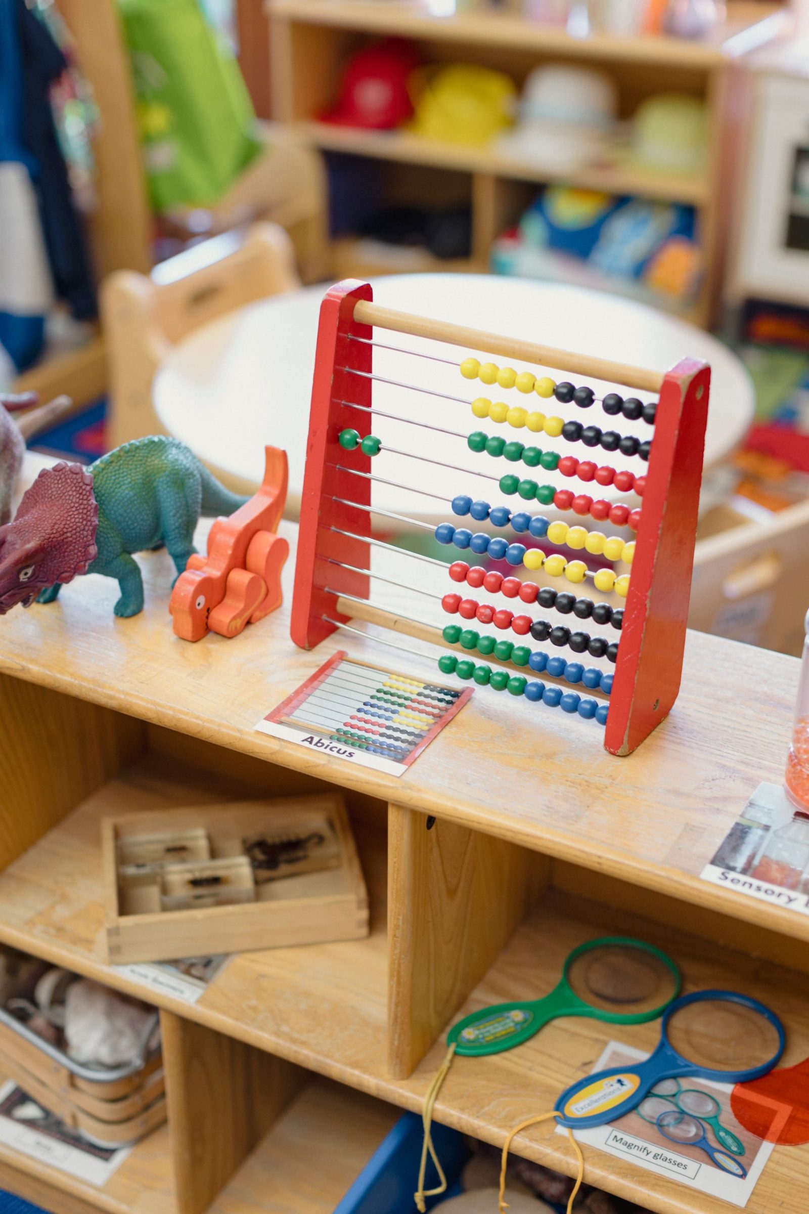 Learning tools are displayed on a shelf in a pre-k class.