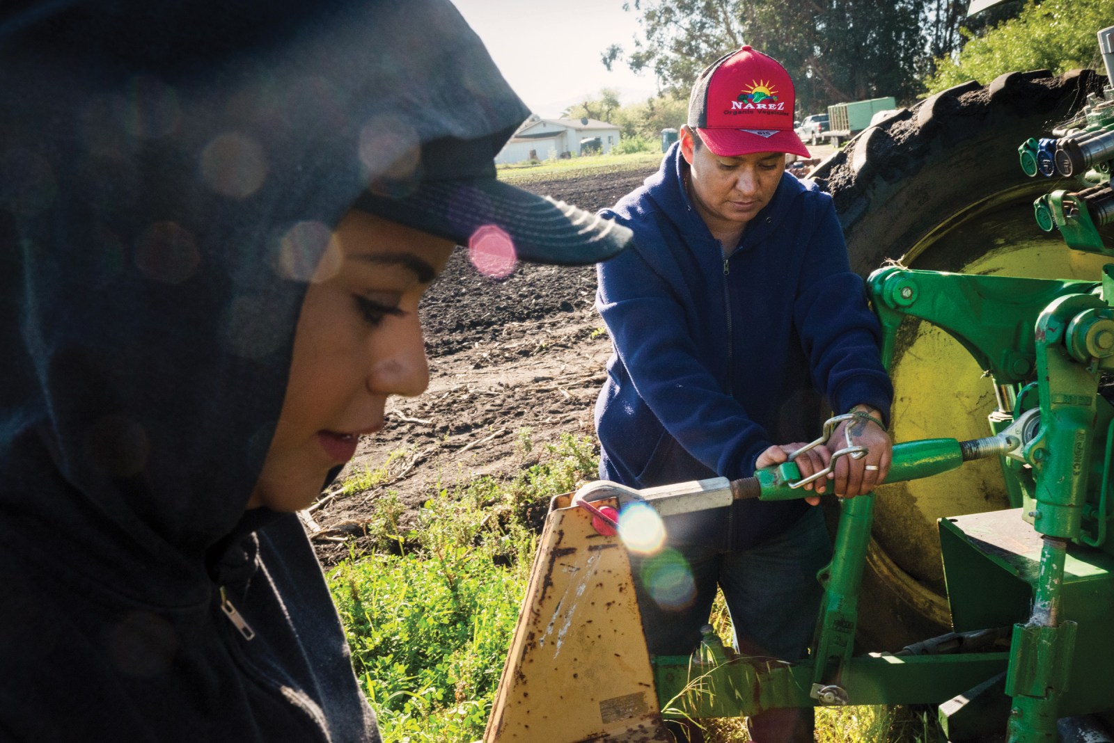 Maria Narez, right, and her wife, Esme, prepare their tractor for field work.