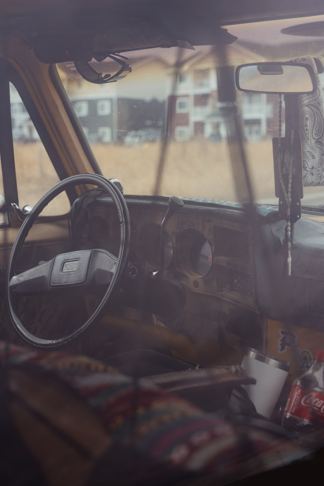 Interior of vehicle being lived in by a Bozeman resident, with new housing development in background.