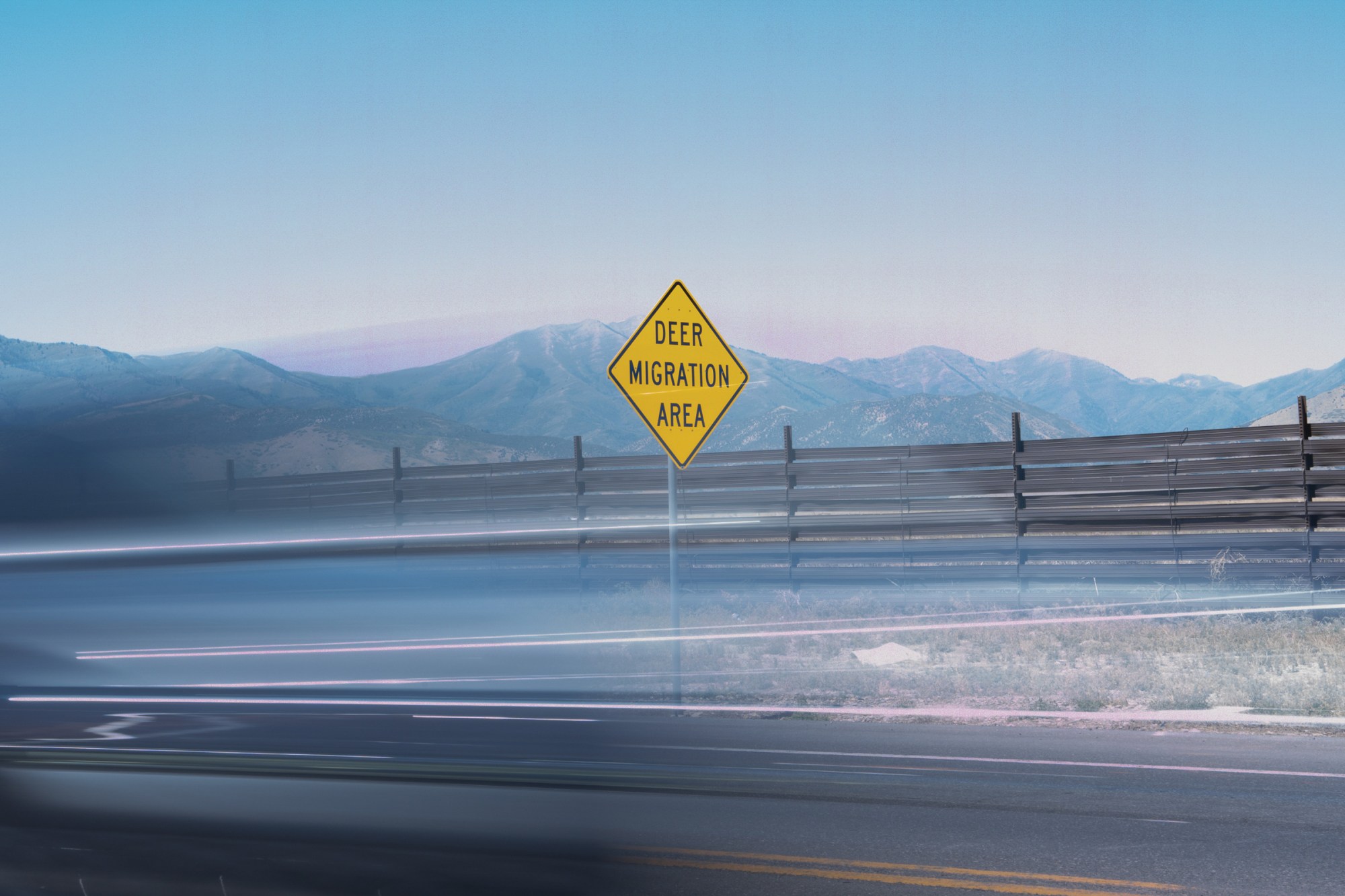 Cars speed past wildlife fencing just west of Eagle Mountain, Utah.